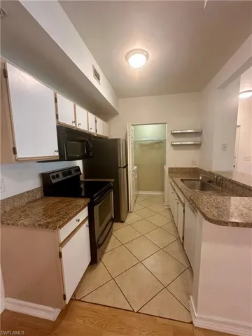 Kitchen with white cabinetry, a sink, visible vents, a peninsula, and appliances with stainless steel finishes