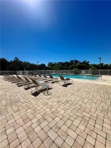 Pool with a patio area and fence