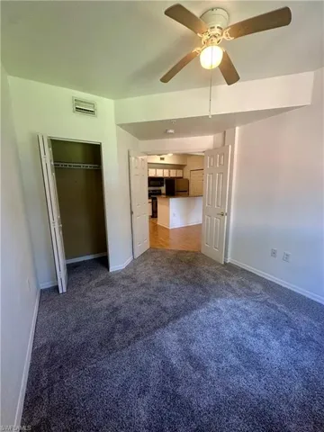 Unfurnished bedroom with baseboards, ceiling fan, and carpet
