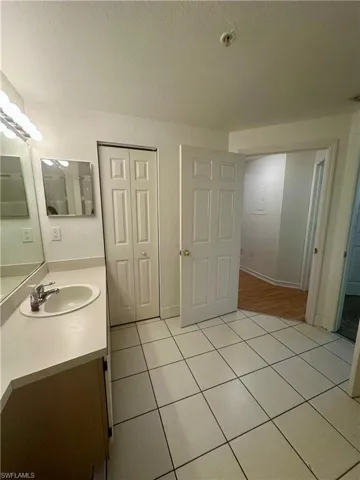 Bathroom with tile patterned floors, vanity, and a textured ceiling