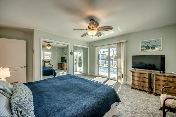 Bedroom featuring ceiling fan, access to exterior, and light carpet
