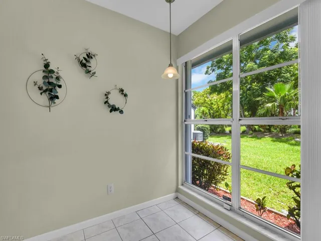 Unfurnished dining area featuring light tile patterned flooring and baseboards