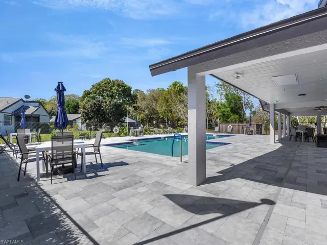 Community pool with a patio area and outdoor dining area