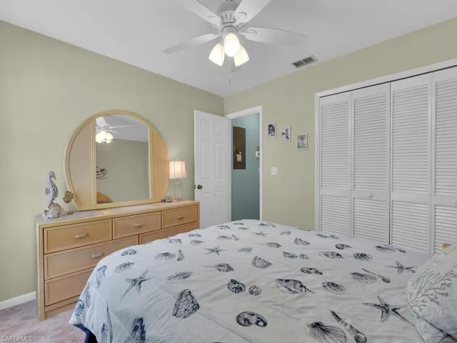 Bedroom featuring a closet, ceiling fan, and light carpet