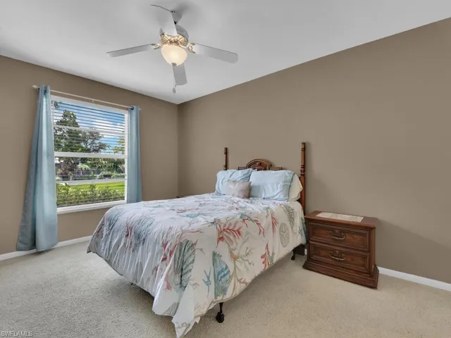 Bedroom with light colored carpet and a ceiling fan