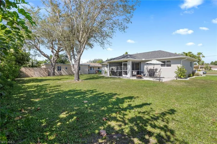 Back of property with a yard, a patio, and a sunroom