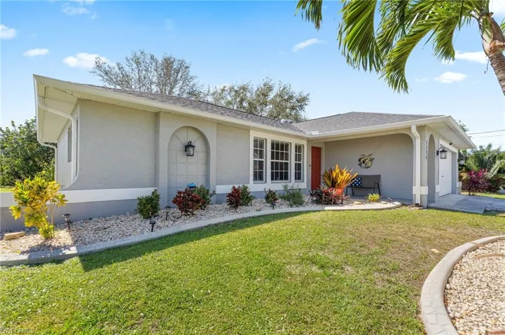 Ranch-style home with a front lawn and a garage