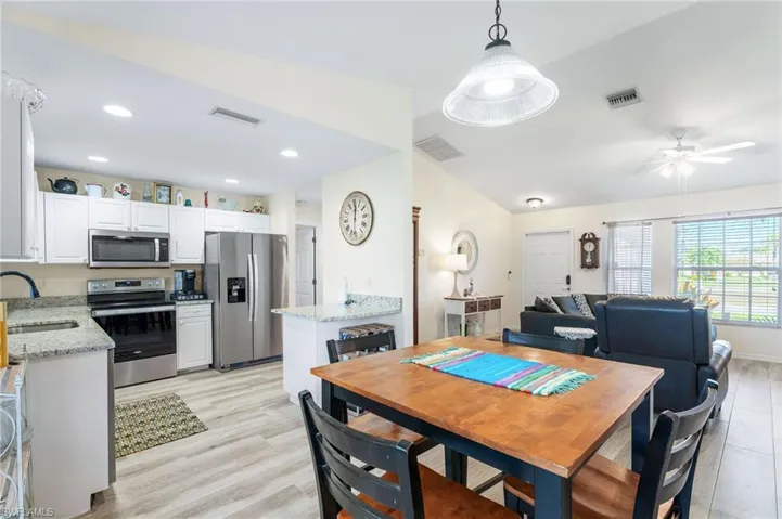 Dining space with ceiling fan, sink, and light hardwood / wood-style floors
