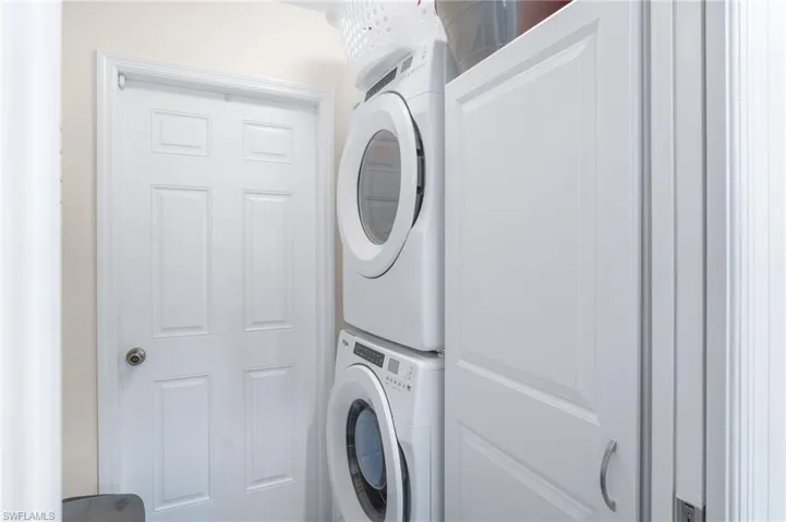 Laundry room with stacked washer and clothes dryer