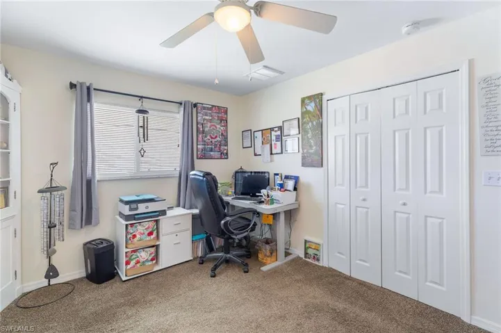 Carpeted office space featuring ceiling fan