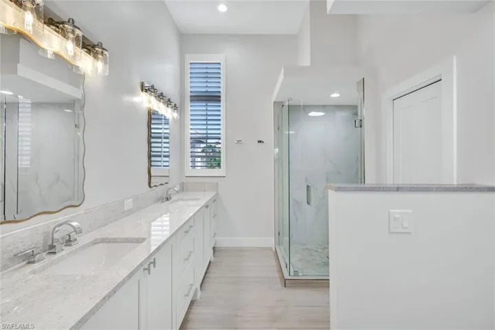 The ensuite primary bathroom with walk in shower, dual sinks and gorgeous cabinetry.