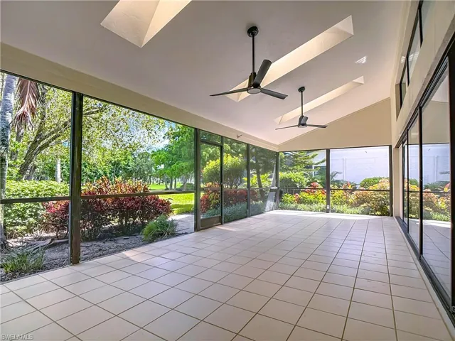 Unfurnished sunroom with a skylight, lofted ceiling, and tile patterned flooring