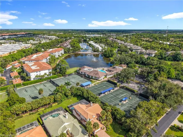 Aerial view of residential area with a large body of water and a tree filled landscape