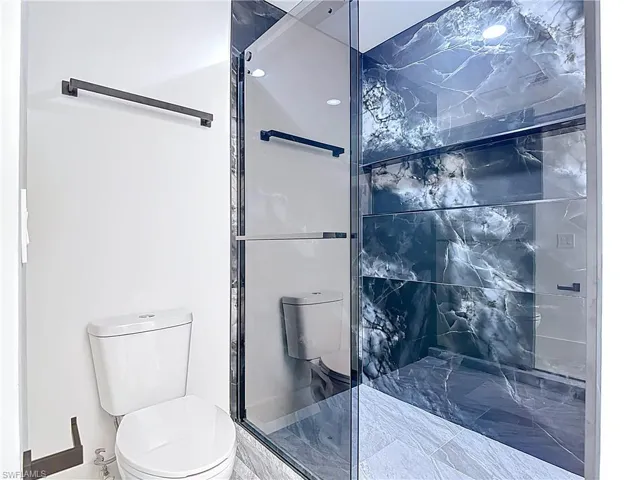 Bathroom featuring a stall shower and toilet
