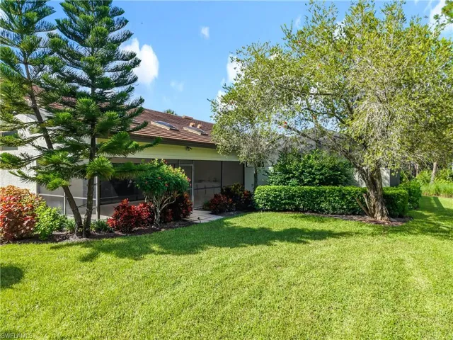View of grassy yard with a sunroom