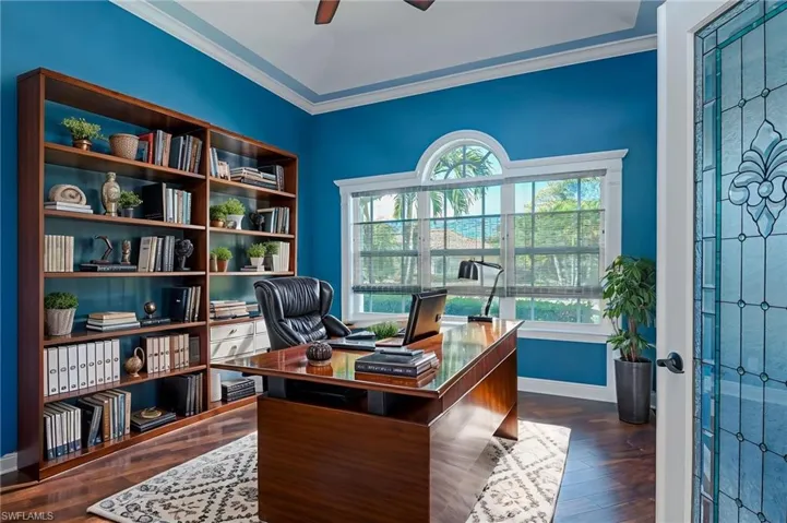 Office space with cherry woodflooring, a ceiling fan, and ornamental molding