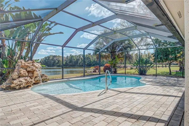 Outdoor pool with a lanai, a water view, a patio, and a sunroom