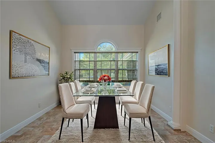 Dining space featuring baseboards and light stone finish floors