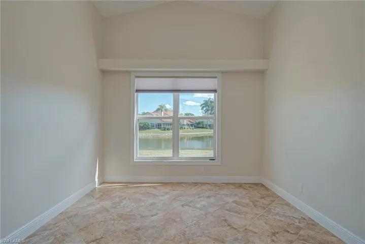 Unfurnished room with a water view and vaulted ceiling