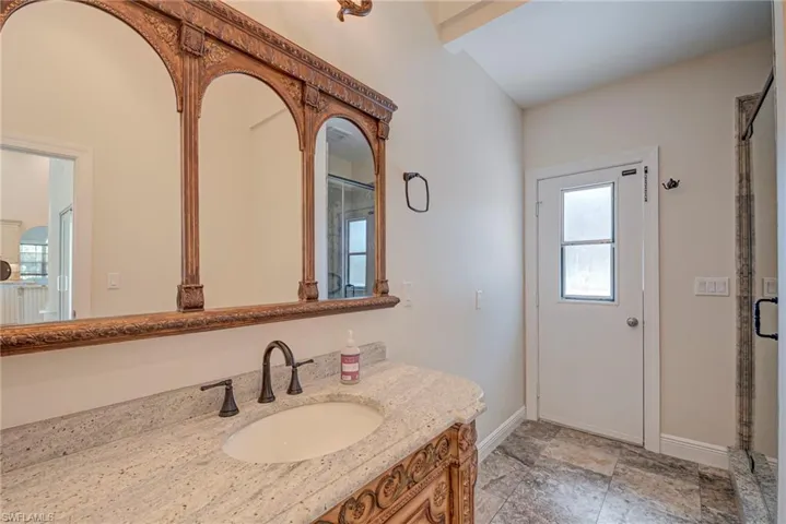 Full bath with a shower stall, vanity, and stone finish floors