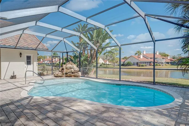 Outdoor pool with a sunroom, a water view, glass enclosure, and a residential view