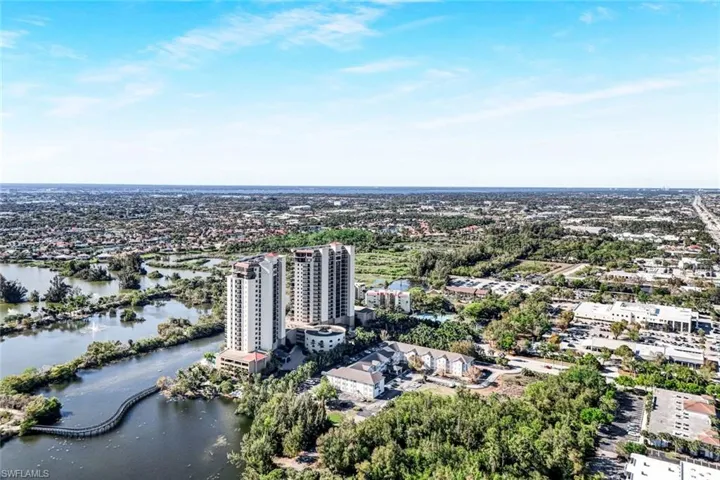 Bird's eye view of Condo complex/building and a nearby body of water in the park