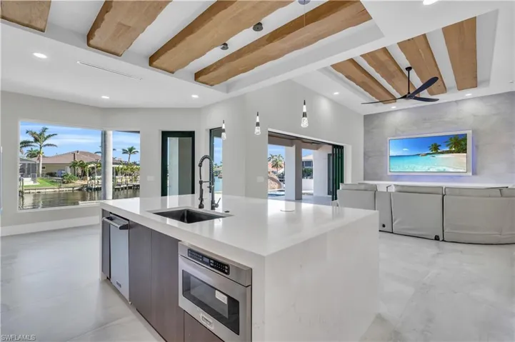 Kitchen featuring modern cabinets, high end appliances, extractor fan, light stone counters, and recessed lighting