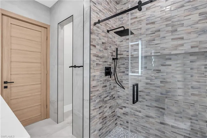 Full bath featuring tile walls, a walk in shower, vanity, tile patterned floors, and a freestanding bath