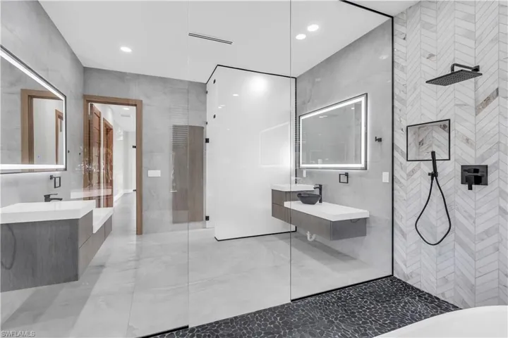Full bathroom featuring tile walls, double vanity, and marble tiled flooring
