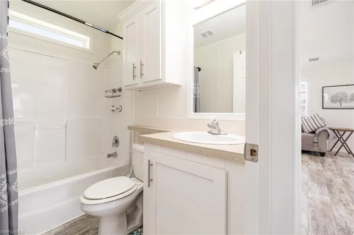 Bedroom featuring multiple closets, light wood finished floors, crown molding, and ceiling fan