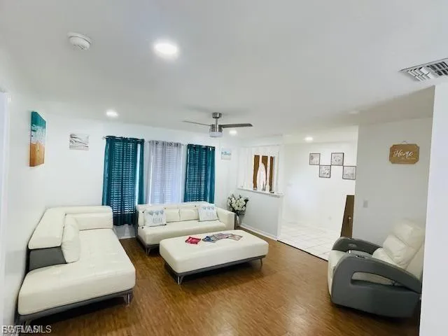 Living room featuring wood finished floors, ceiling fan, and recessed lighting