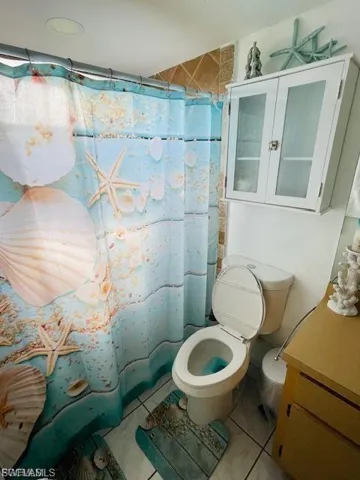 Bathroom with tile patterned flooring, a shower with curtain, and vanity