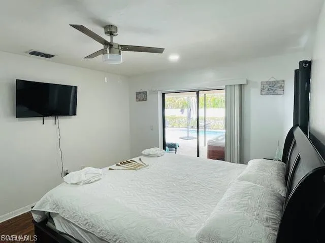 Bedroom featuring access to exterior, a ceiling fan, and dark wood-style floors