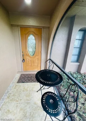 Doorway to property with a balcony and stucco siding