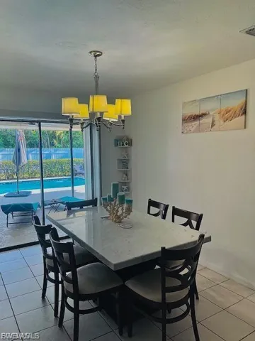 Dining area featuring light tile patterned floors and a chandelier