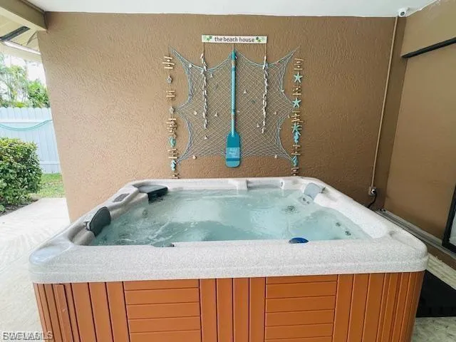 Misc room with a jacuzzi and a textured wall