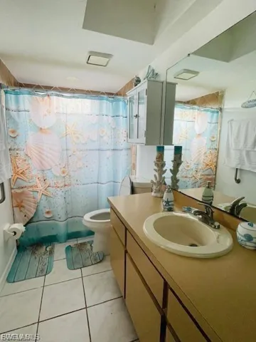 Bathroom featuring vanity, tile patterned flooring, and a shower with shower curtain