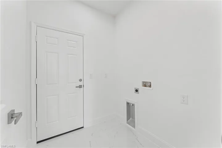Laundry area with marble finish floor, hookup for a washing machine, electric dryer hookup, laundry area, and baseboards