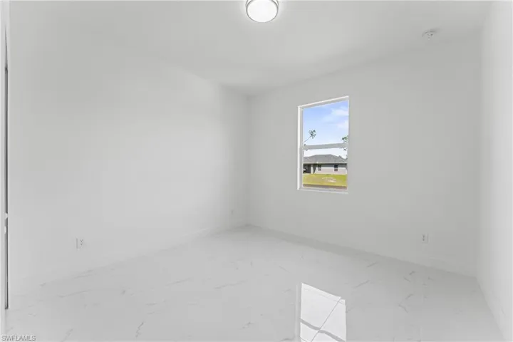 Spare room featuring marble finish floor and baseboards