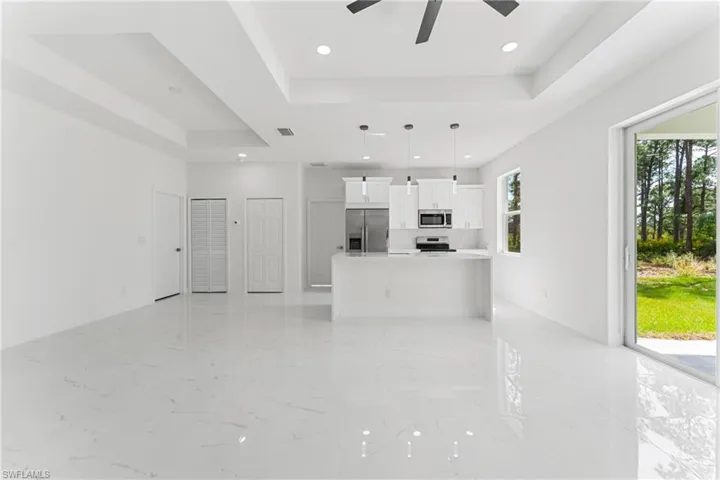 Unfurnished living room with marble finish floor, recessed lighting, a raised ceiling, visible vents, and a ceiling fan