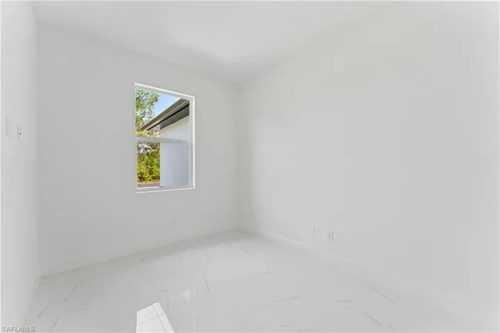 Empty room featuring marble finish floor and baseboards