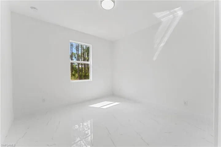 Unfurnished room with marble finish floor and baseboards