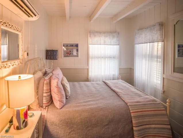 Guest Bedroom prior to Hurricane Helene featuring beamed ceiling, wooden walls prior to Hurricane Helene featuring and a wall mounted Mini Split AC/HEAT