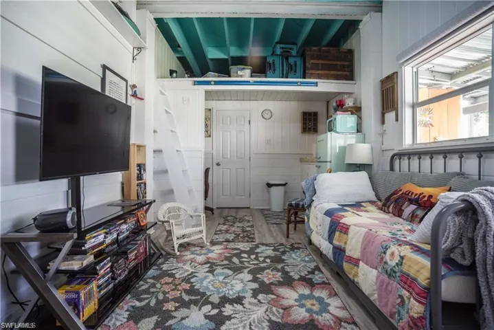 ground floor Sunroom/game room prior to Hurricane Helene featuring a wall unit AC and ceiling fan