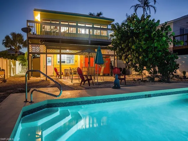 Pool prior to Hurricane Helene at dusk featuring a wooden deck and a patio