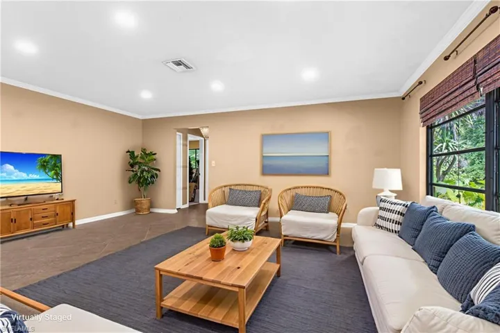 Living room with crown molding, tile patterned floors, and recessed lighting