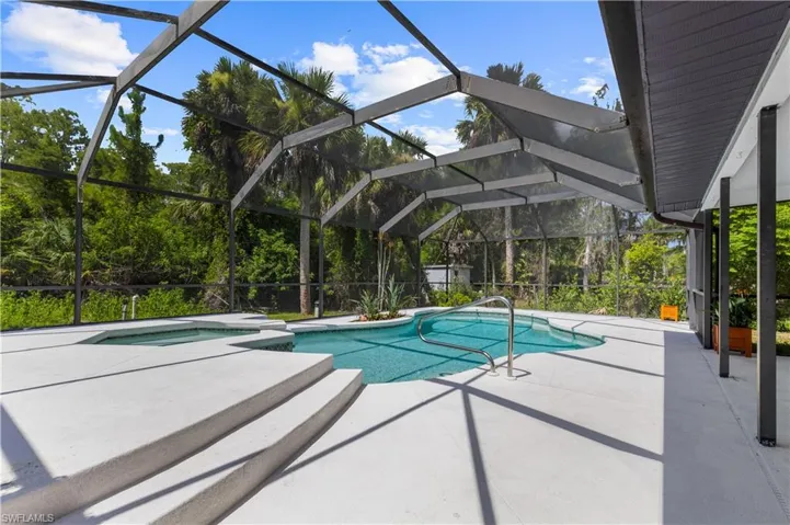 View of pool with a patio, a pool with connected hot tub, and a lanai