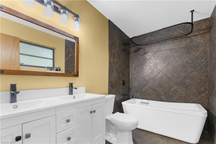 Bathroom with double vanity and tub / shower combination