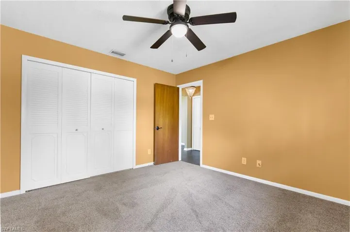 Unfurnished bedroom featuring carpet floors, a closet, and a ceiling fan