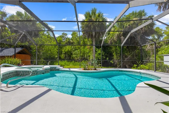 View of pool with a patio, a pool with connected hot tub, and a lanai